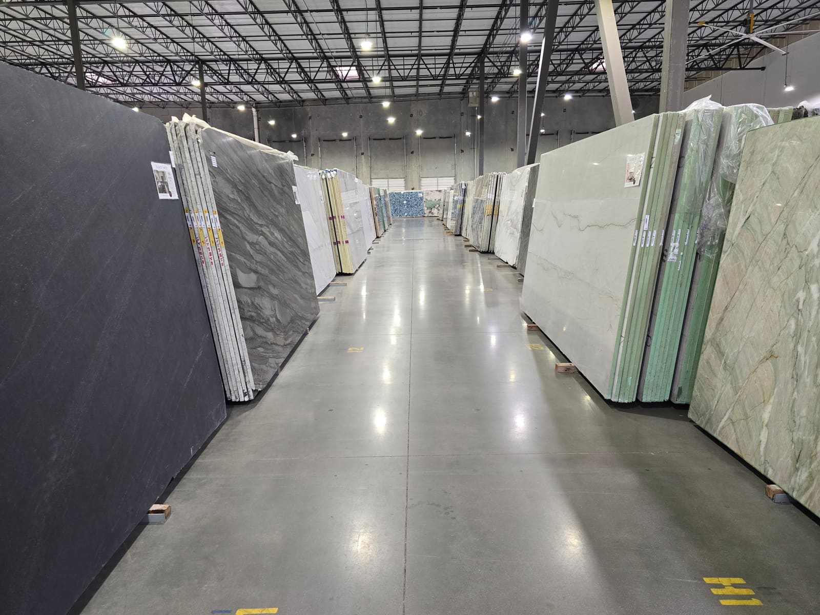 An organized aisle of full stone slabs on the CRS floor, ready for trade clients